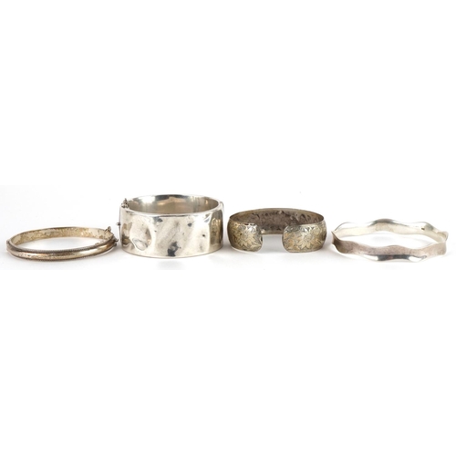 3588 - Three silver bangles and a white metal floral bangle, total weight 74.0g