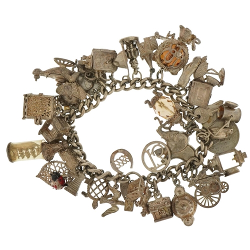 3547 - Heavy silver charm bracelet with a large selection of mostly silver charms including stork with new ... 