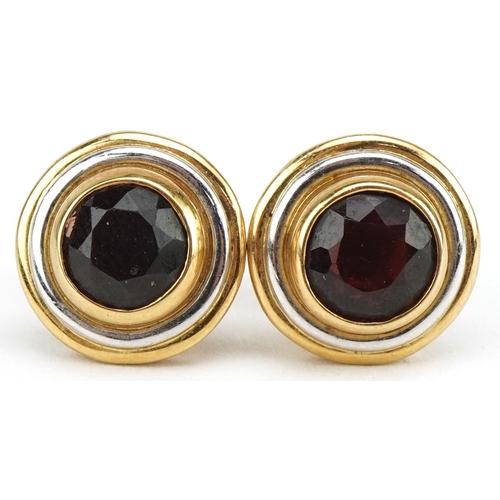 3139 - Pair of two tone gold garnet solitaire stud earrings, the backs marked 750, 13mm in diameter, 7.7g