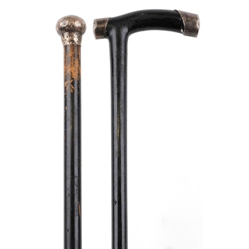 664 - Two ebonised walking sticks with silver mounts and brass ferules, the largest 86cm in length