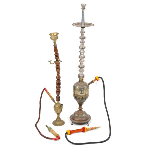 1319 - Two Islamic floor standing shisha pipes including a white metal example, the largest 118cm high