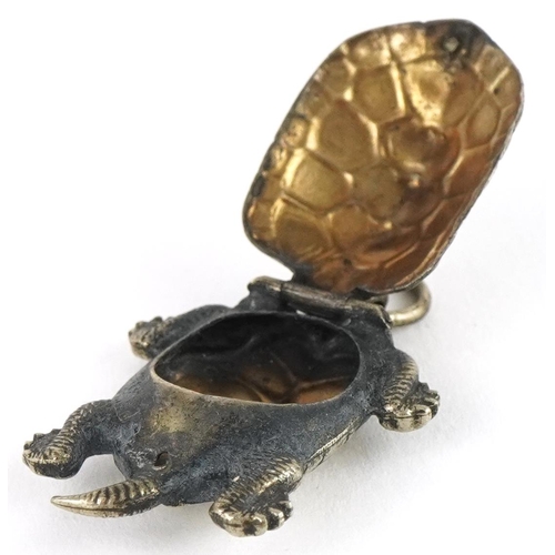 2672 - Unmarked silver tortoise pendant with hinged back and gilt interior, 3cm high, 2.5g