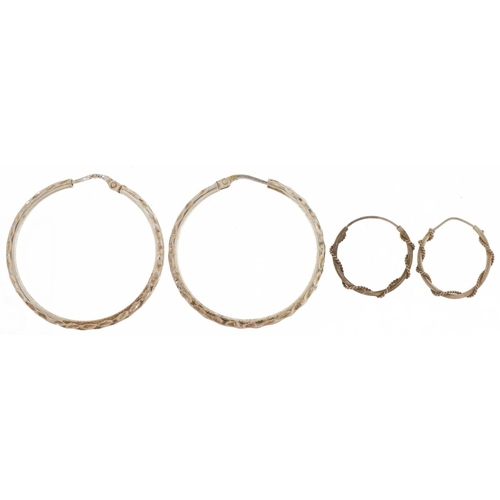 2827 - Two pairs of silver hoop earrings including one pair engine turned, the largest 3.5cm in diameter, t... 