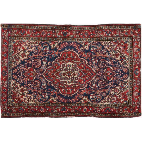 2194 - Rectangular Persian blue and red ground rug having and allover floral design, 146cm x 103cm