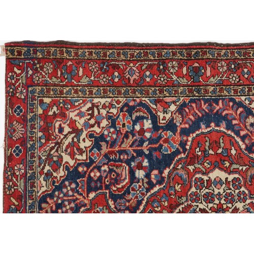 2194 - Rectangular Persian blue and red ground rug having and allover floral design, 146cm x 103cm