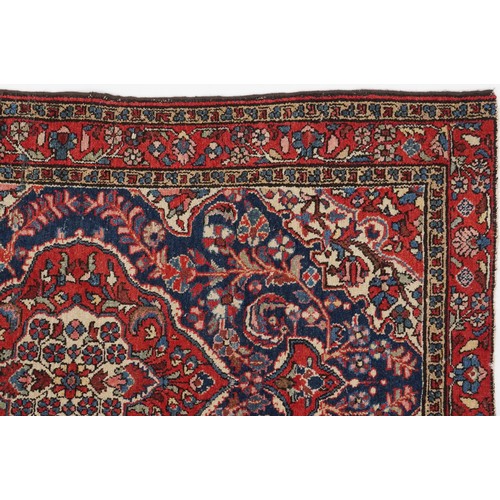 2194 - Rectangular Persian blue and red ground rug having and allover floral design, 146cm x 103cm