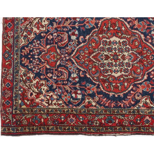 2194 - Rectangular Persian blue and red ground rug having and allover floral design, 146cm x 103cm