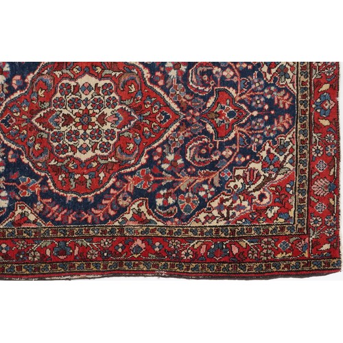 2194 - Rectangular Persian blue and red ground rug having and allover floral design, 146cm x 103cm