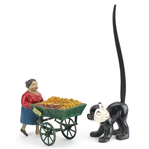 Vintage clockwork street trader and a novelty porcelain monkey with wagging tail, the largest 24cm wide