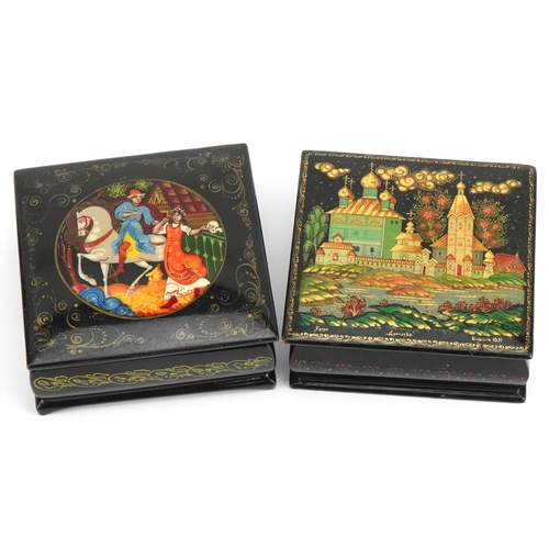 1143 - Two Russian black lacquered boxes with hinged lids including one hand painted with a figure on horse... 