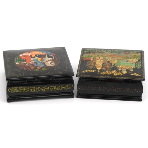 1143 - Two Russian black lacquered boxes with hinged lids including one hand painted with a figure on horse... 