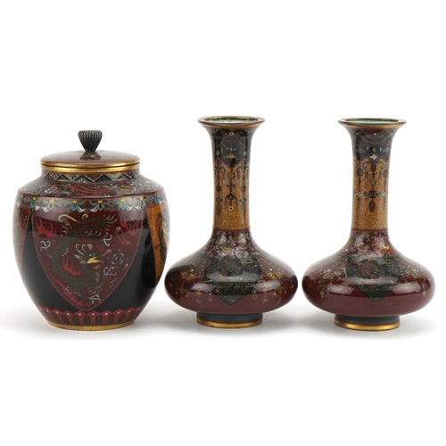 71 - Japanese cloisonne comprising a pair of vases and a jar and cover enamelled with phoenixes and mythi... 