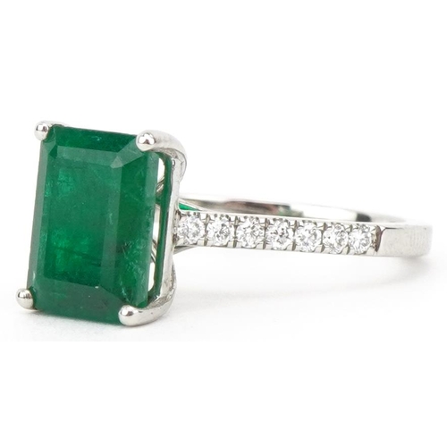 2205 - Platinum octagonal step cut emerald ring with diamond set shoulders, the emerald approximately 3.0 c... 