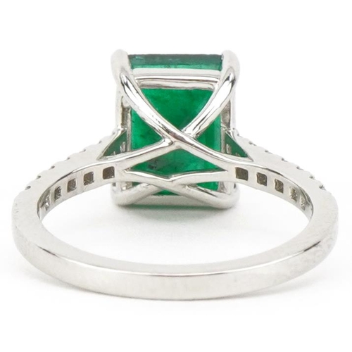 2205 - Platinum octagonal step cut emerald ring with diamond set shoulders, the emerald approximately 3.0 c... 