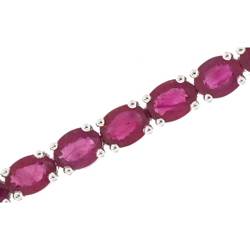 2081 - 18ct white gold oval ruby line bracelet, total ruby weight approximately 10.28 carat, 18cm in length... 