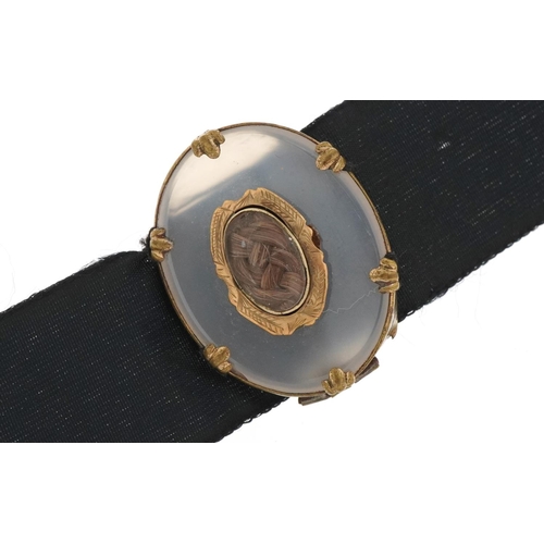 2716 - Victorian moonstone and hairwork mourning brooch mounted on a silk ribbon, the brooch 3.2cm wide