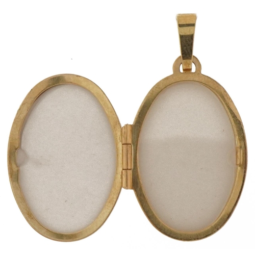 2041 - 9ct gold oval engraved locket, 3cm high, 2.8g