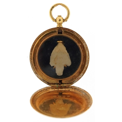 2113 - 18ct gold engine turned locket housing a flint arrow head, 3.3cm high, 10.0g