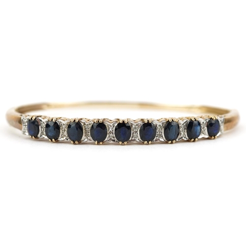 2109 - 9ct gold graduated sapphire and diamond hinged bangle, the largest sapphire approximately 5.20mm x 4... 