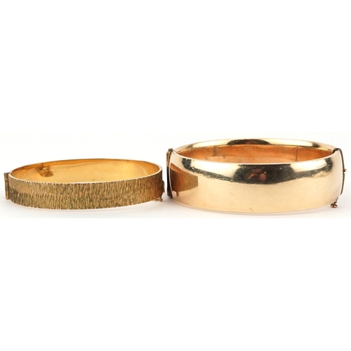 2752 - Two 9ct gold metal core hinged bangles, one with engraved decoration, the largest 7cm in diameter, t... 