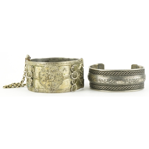 2842 - Two Middle Eastern white metal bangles, the largest 6cm in diameter, total 100.8g