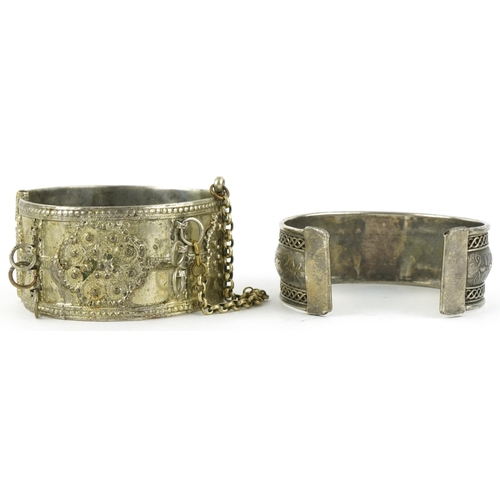 2842 - Two Middle Eastern white metal bangles, the largest 6cm in diameter, total 100.8g