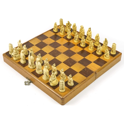 1360 - Chinese ivorine chess set housed in a fitted folding chess board, the chess board 39cm x 40cm