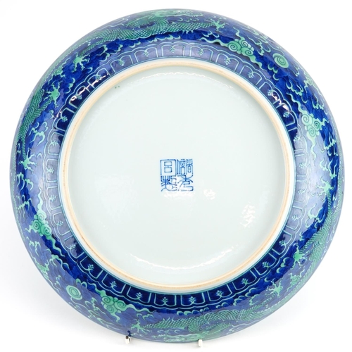 119 - Large Chinese porcelain blue ground charger hand painted with dragons chasing the flaming pearl amon... 