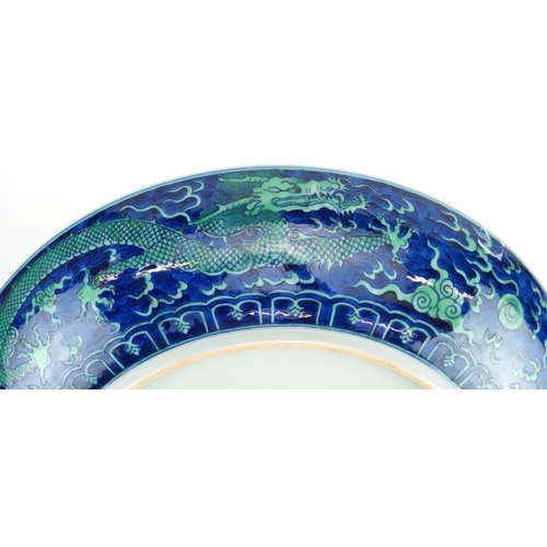 119 - Large Chinese porcelain blue ground charger hand painted with dragons chasing the flaming pearl amon... 