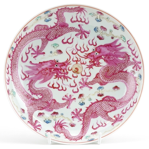 20 - Chinese porcelain shallow dish hand painted with two dragons chasing the flaming pearl amongst cloud... 