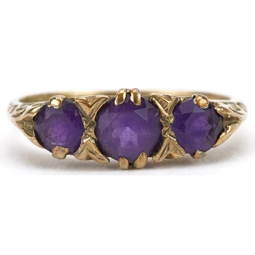 2573 - 9ct gold amethyst three stone ring with ornate scrolled setting, size L, 2.0g