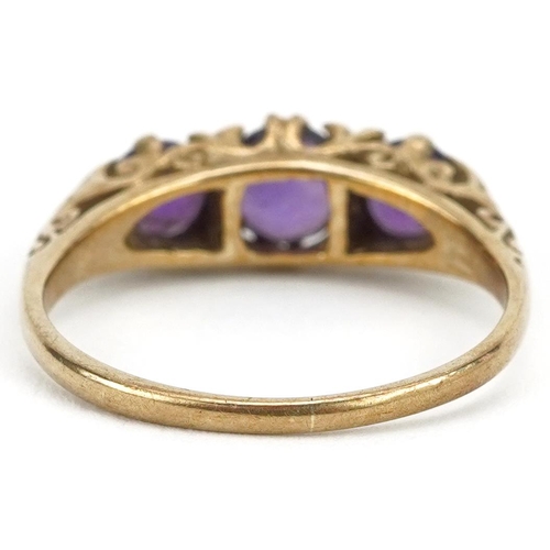 2573 - 9ct gold amethyst three stone ring with ornate scrolled setting, size L, 2.0g