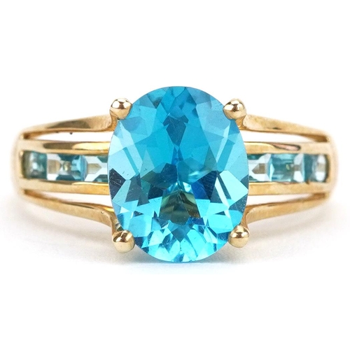 2123 - 9ct gold blue topaz solitaire ring with blue spinel set shoulders, the topaz approximately 10.0mm x ... 