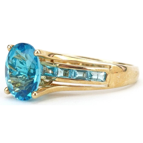 2123 - 9ct gold blue topaz solitaire ring with blue spinel set shoulders, the topaz approximately 10.0mm x ... 