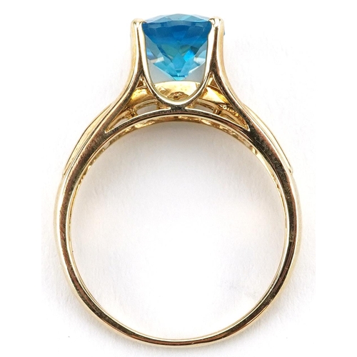 2123 - 9ct gold blue topaz solitaire ring with blue spinel set shoulders, the topaz approximately 10.0mm x ... 