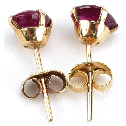 2587 - Pair of unmarked gold ruby solitaire stud earrings, tests as 9ct gold, the rubies each approximately... 