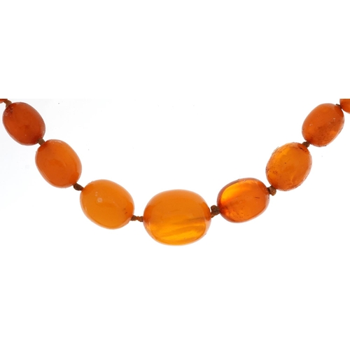 2115 - Butterscotch amber coloured graduated bead necklace, the largest bead approximately 1.9cm wide, over... 