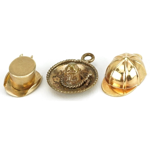 2704 - Three hat charms comprising 9ct gold jockey cap, unmarked gold top hat and yellow metal Mexican somb... 