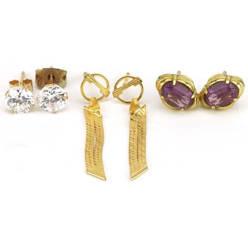 2596 - Three pairs of yellow metal earrings including clear stone studs and flattened weave drops, the larg... 