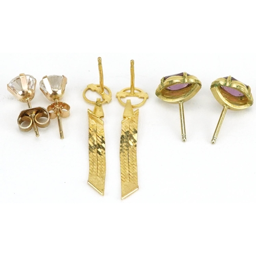 2596 - Three pairs of yellow metal earrings including clear stone studs and flattened weave drops, the larg... 