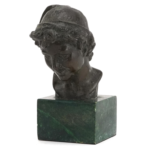 253 - Patinated bronze head and shoulders bust of a young female wearing a hat raised on a green marble ba... 