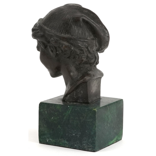 253 - Patinated bronze head and shoulders bust of a young female wearing a hat raised on a green marble ba... 