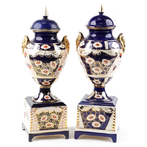 1243 - Large pair of Imari pattern pottery vases and covers with figural handles, each 61.5cm high