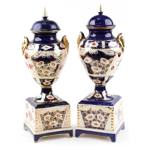 1243 - Large pair of Imari pattern pottery vases and covers with figural handles, each 61.5cm high