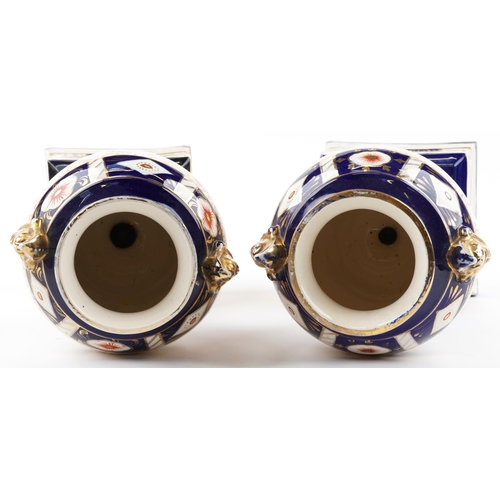 1243 - Large pair of Imari pattern pottery vases and covers with figural handles, each 61.5cm high