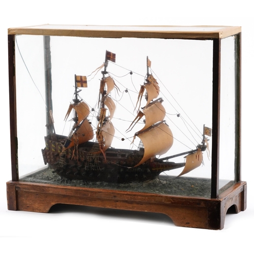 491 - Hand painted wooden model of a rigged battleship housed in a glazed display case, 43cm H x 51cm W x ... 