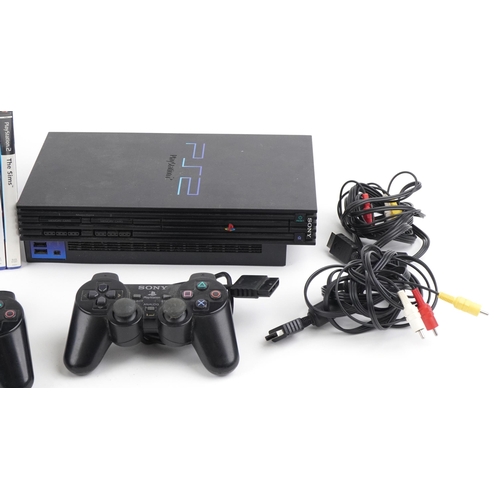 1394 - Two Sony PlayStation 2 games consoles with controllers and a collection of games