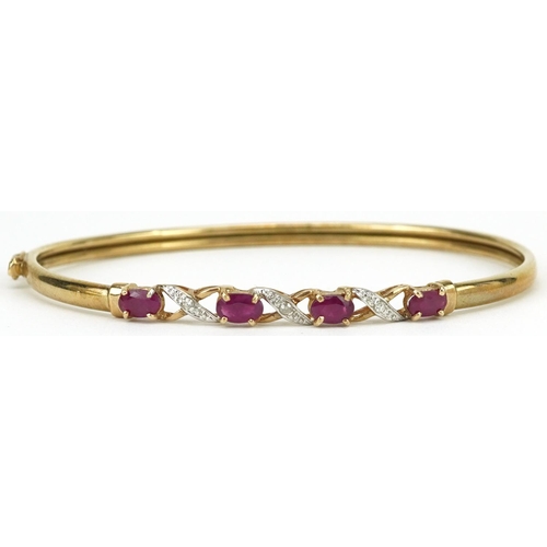 2179 - 9ct gold ruby and diamond crossover hinged bangle, 6.5cm wide, 3.8g