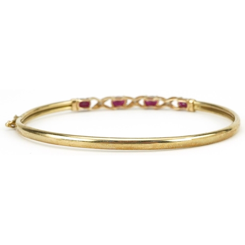 2179 - 9ct gold ruby and diamond crossover hinged bangle, 6.5cm wide, 3.8g