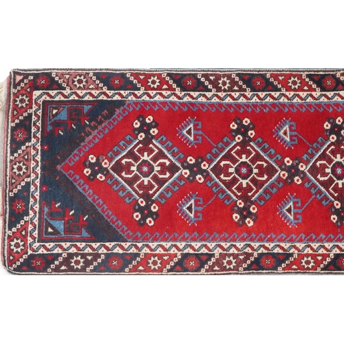 1086 - Turkish Red and blue ground carpet runner having an allover repeat geometric design, 295cm x 75cm